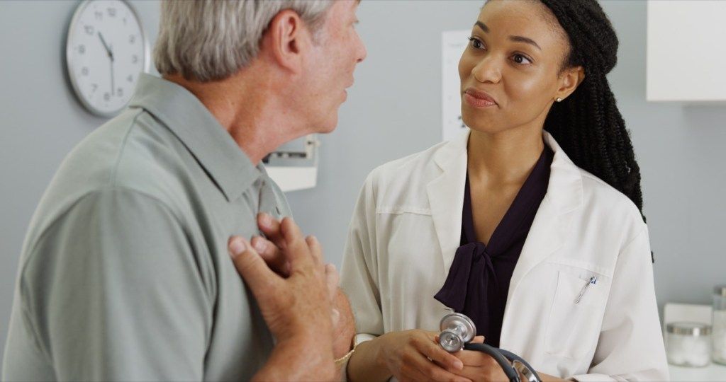 بوڑھا آدمی نوجوان خواتین ڈاکٹر سے بات کر رہا ہے ، دل کی صحت کو خطرہ ہے