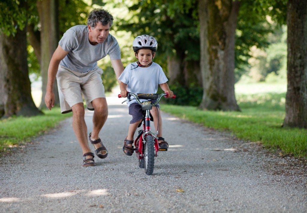 Padre enseñando a su hijo a andar en bicicleta