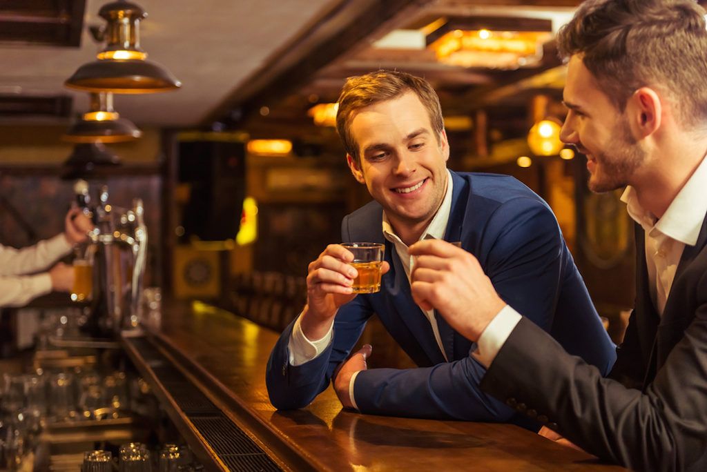 kaksi liikemiestä juo juomassa baarissa