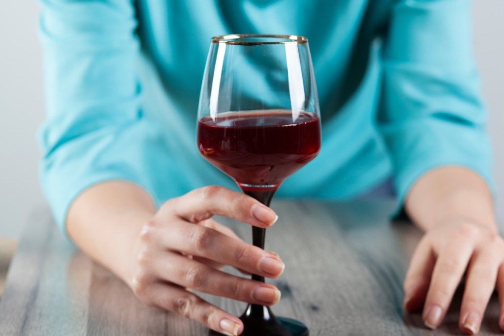 Kvinna med ett glas vin i hennes hand