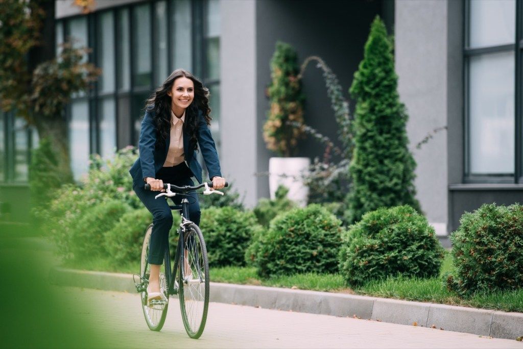 Wanita perniagaan menunggang basikalnya ke tempat kerja