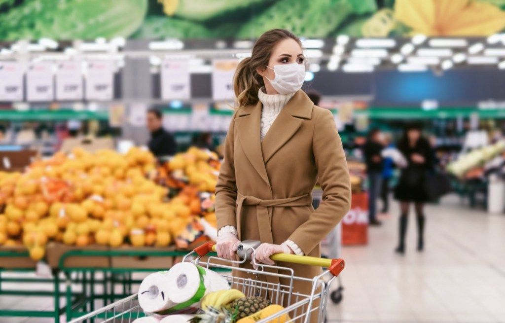 sieviete dodas uz pārtikas preču veikalu ar masku