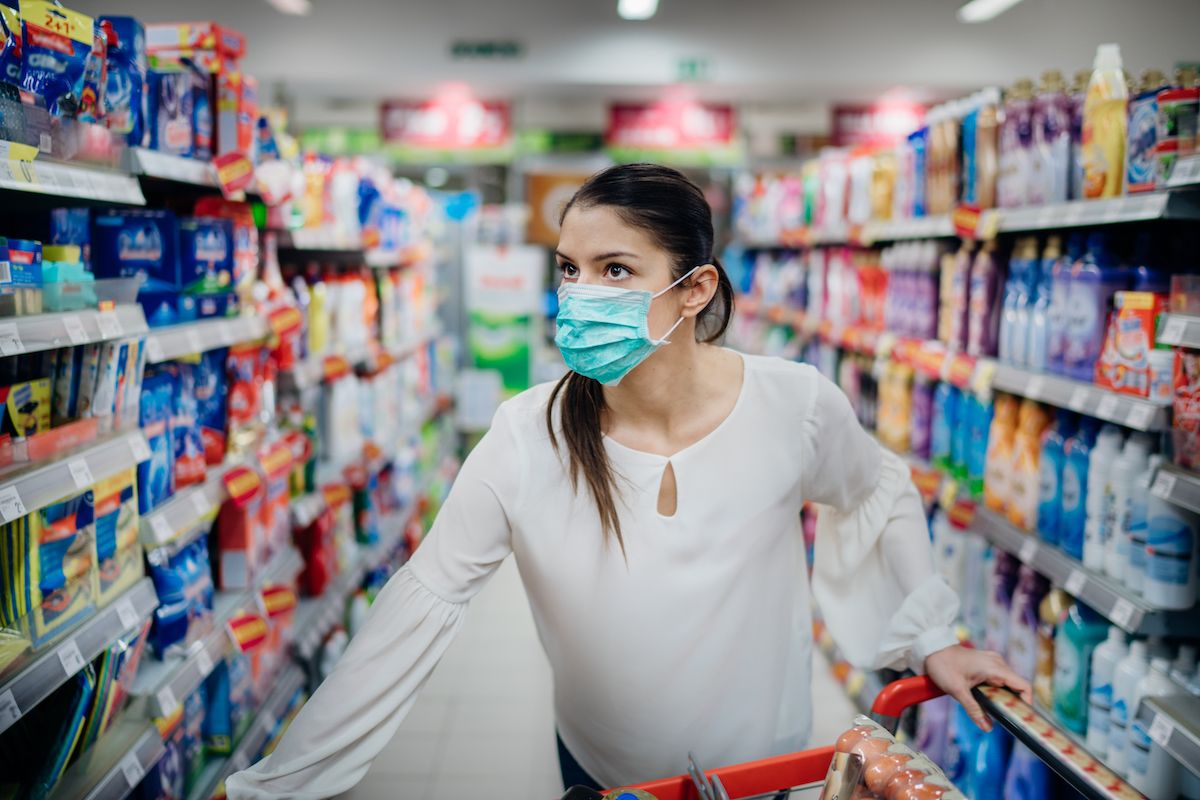सुपरमार्केट में सुरक्षात्मक मुखौटा पहने महिला