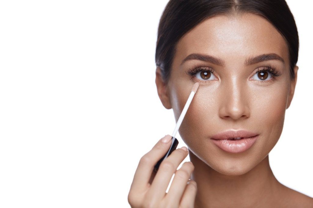 Mujer aplicando maquillaje corrector Body Flaws