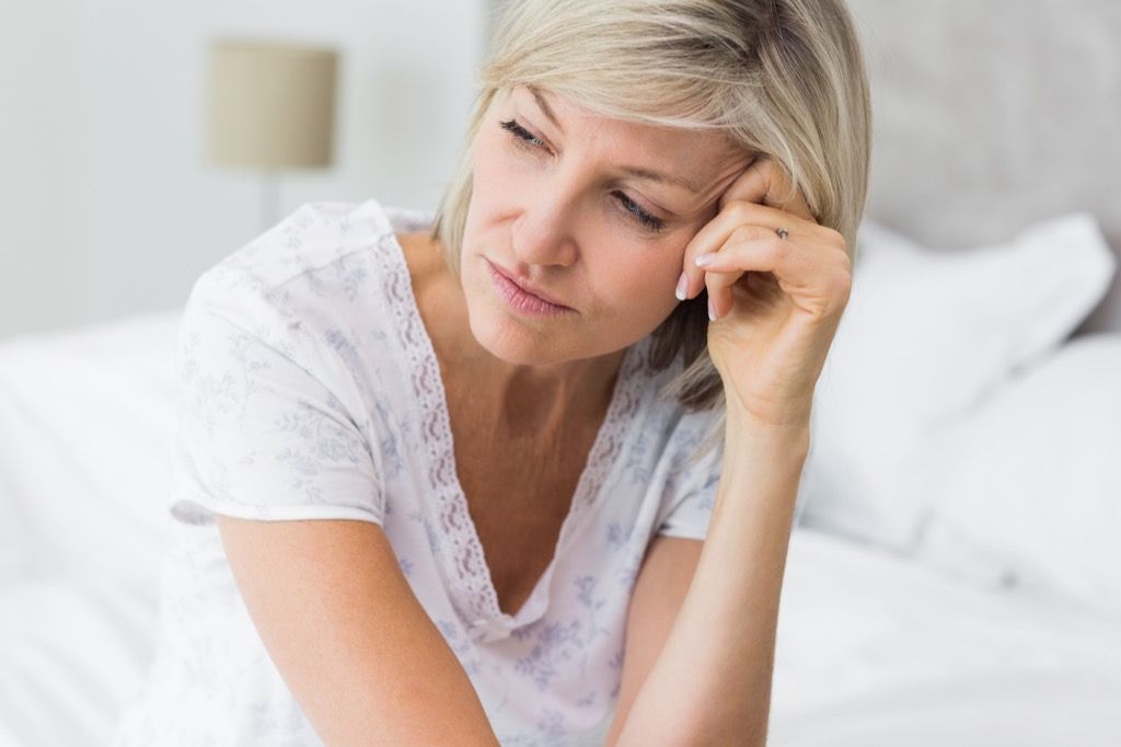 người phụ nữ buồn bã trên giường, dấu hiệu khủng hoảng tuổi trung niên