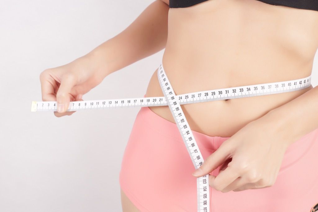 wanita mengukur pita pengukur penurunan berat badan
