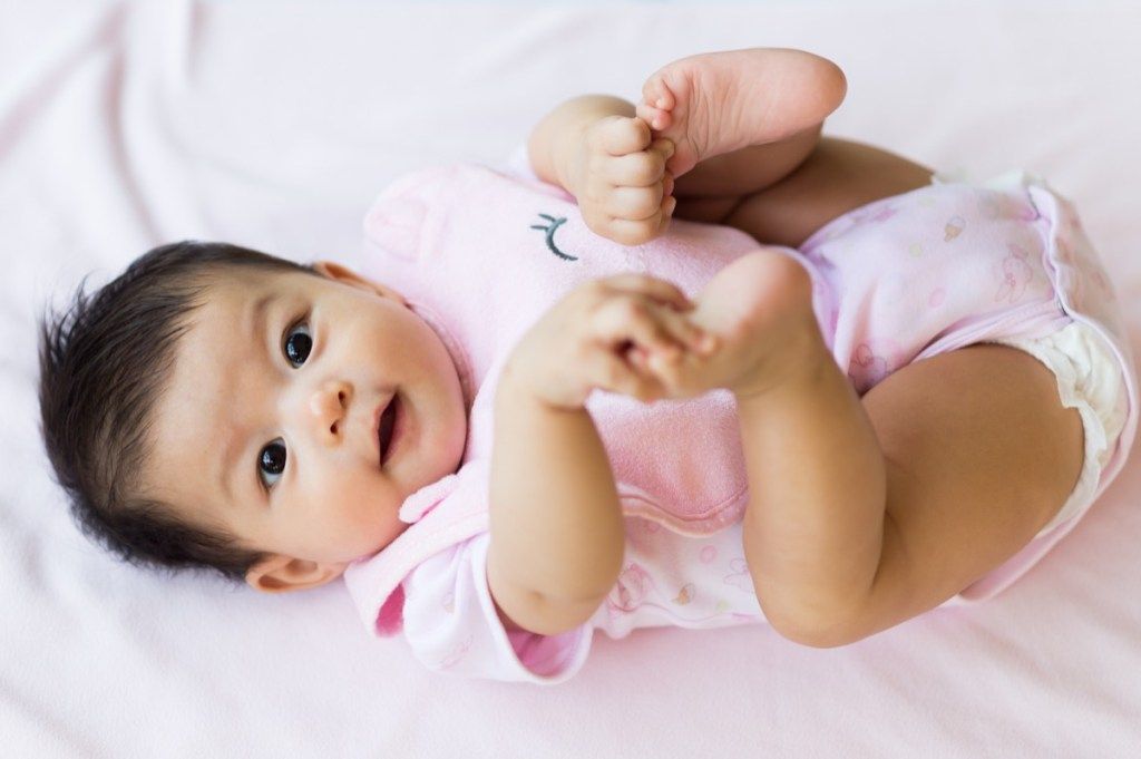 ピンクのカバーオールのアジアの赤ちゃん