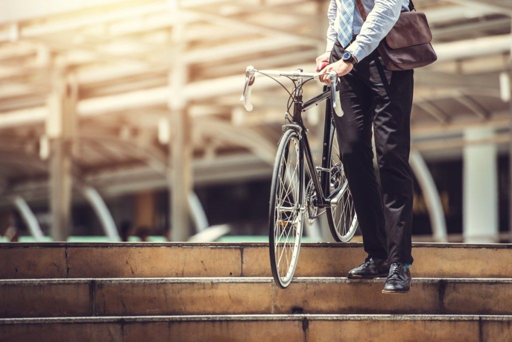 Verslininkas, važiuodamas dviračiu, aktyviai važiuoja į darbą