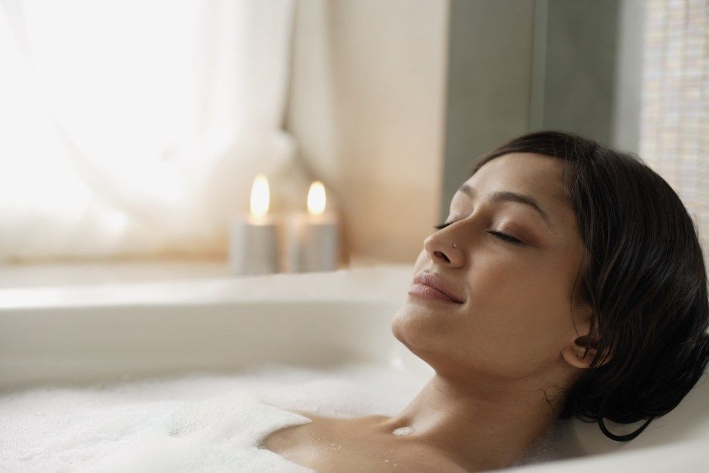 kobieta biorąc relaksującą gorącą kąpiel