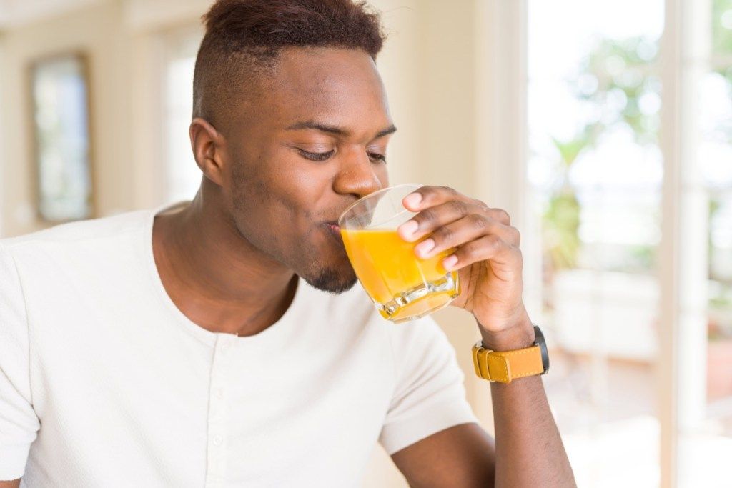Bir bardak portakal suyu içen adam