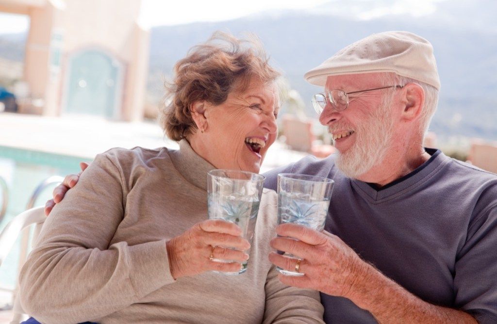 Feliz pareja de ancianos bebiendo agua juntos