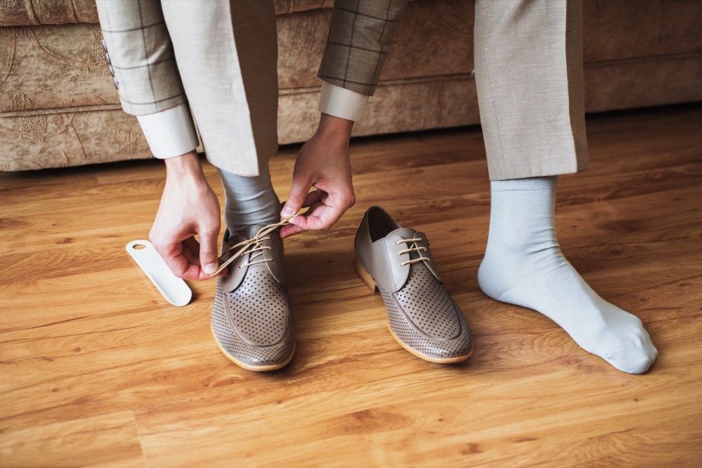 Homme mettant des chaussettes et des chaussures habillées