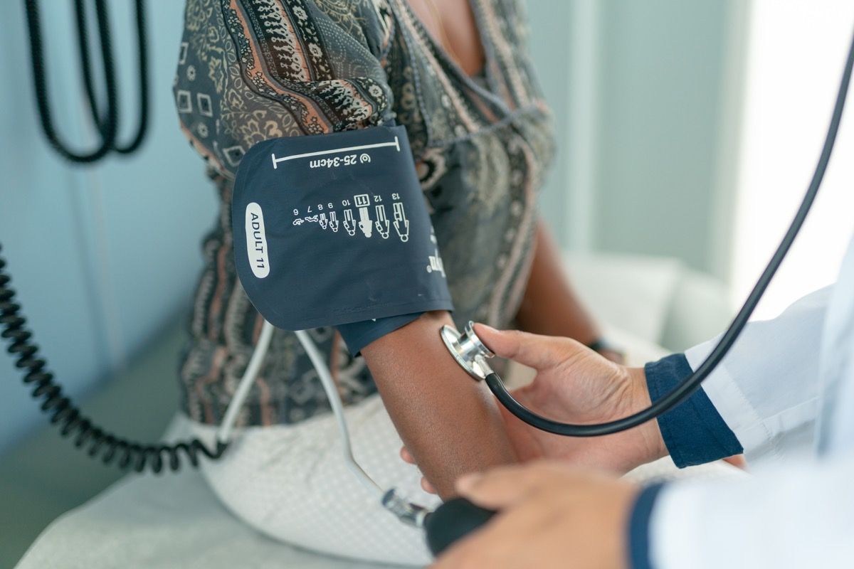 Kvinde får sit blodtryk kontrolleret af læge