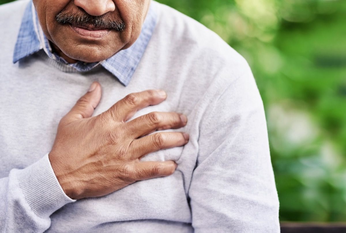 Homem segurando o peito por causa de dor no coração