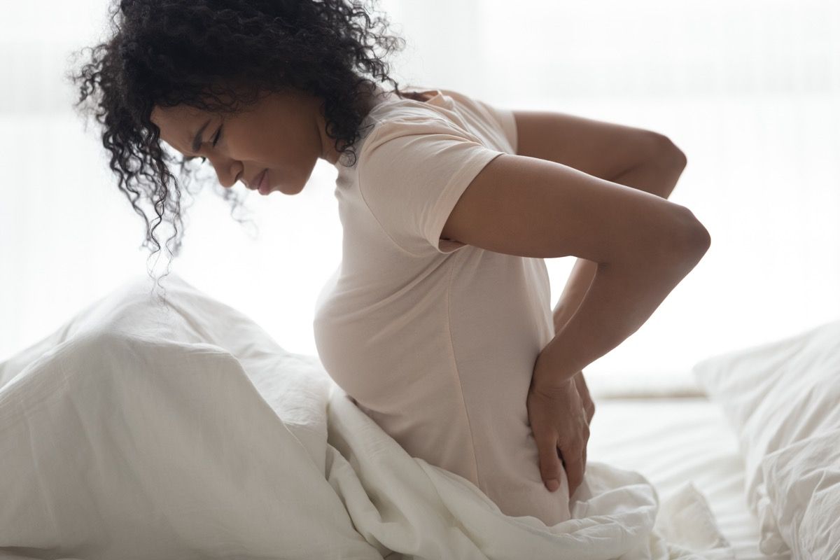 Žena s bolestí ledvin v posteli v bolestech