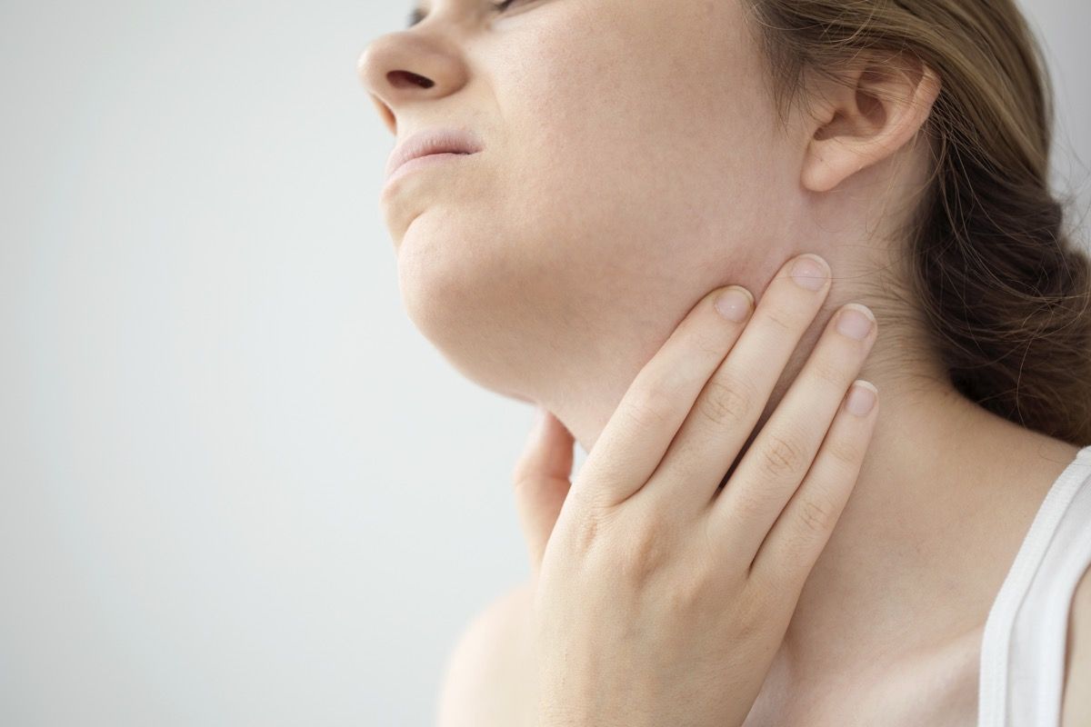 Žena cíti bolesť v krku z opuchnutých lymfatických uzlín