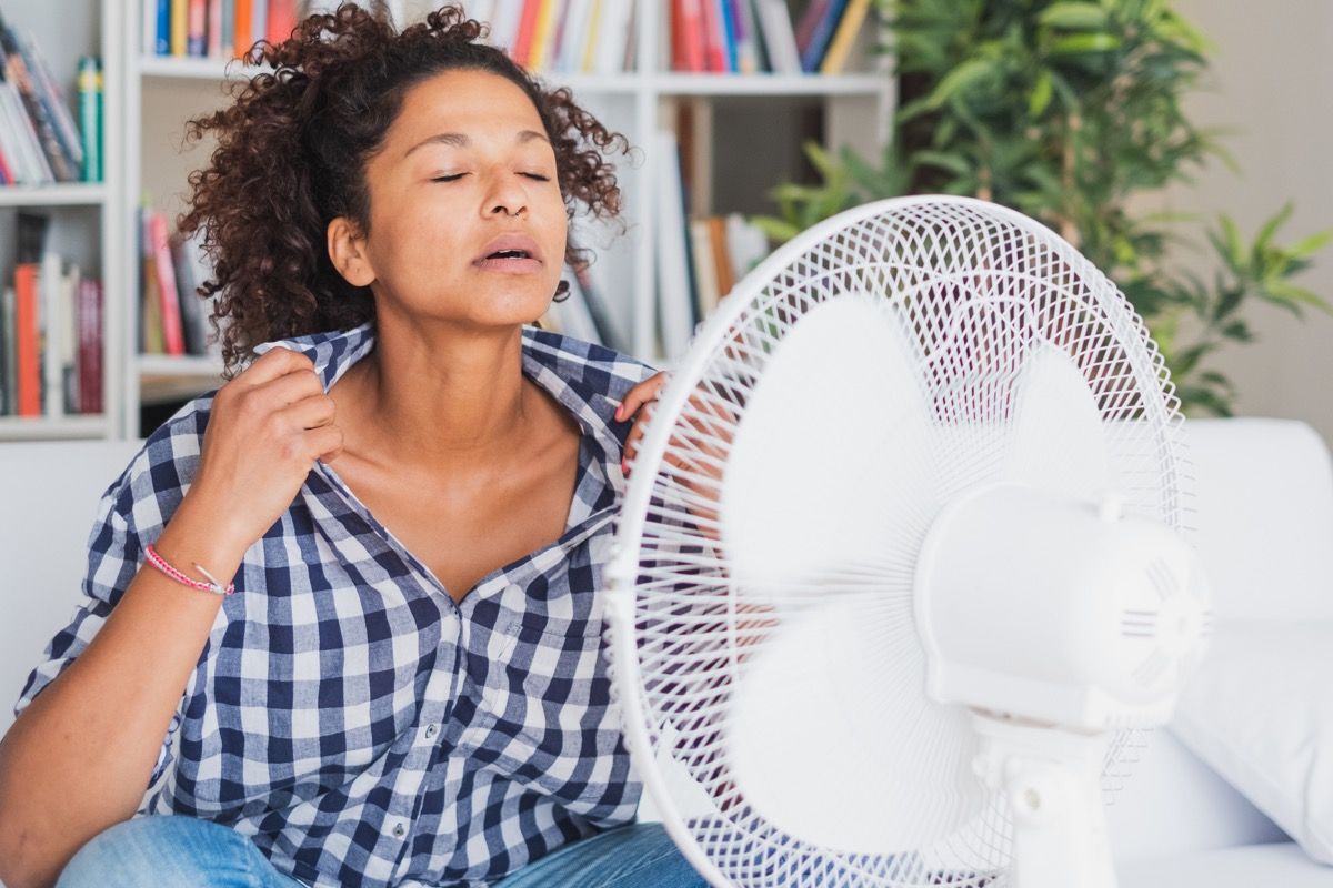Sieviete, kas izmanto ventilatoru, jo viņai ir siltuma nepanesamība