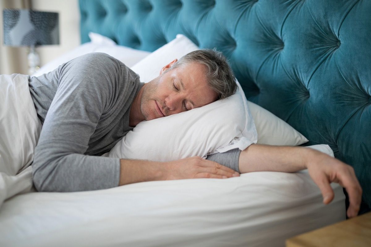Hombre durmiendo durante el día en su cama