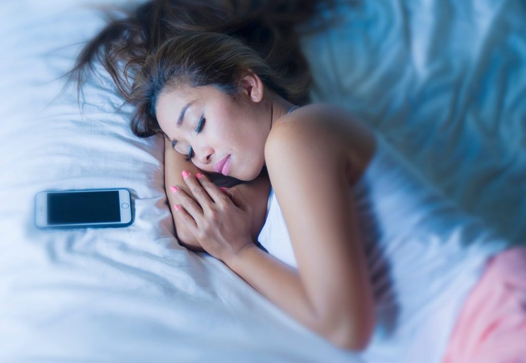 Chica durmiendo junto a las redes sociales del teléfono