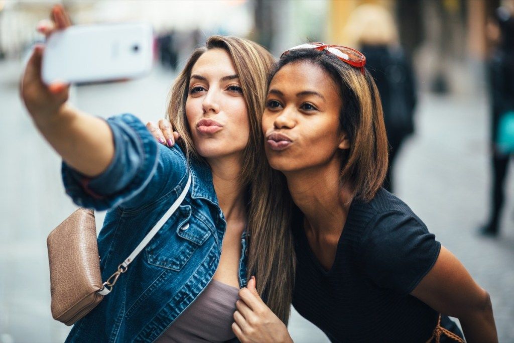 ystävät tekevät ankan kasvot ottaessaan selfieä, älykkäät ihmiset