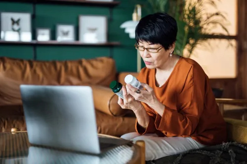   Vanem naine, kes võtab veebis virtuaalse kohtumise arstiga, konsulteerib kodus sülearvutis oma retsepti ja ravimivalikuga. Telemeditsiin, vanurid ja tervishoid