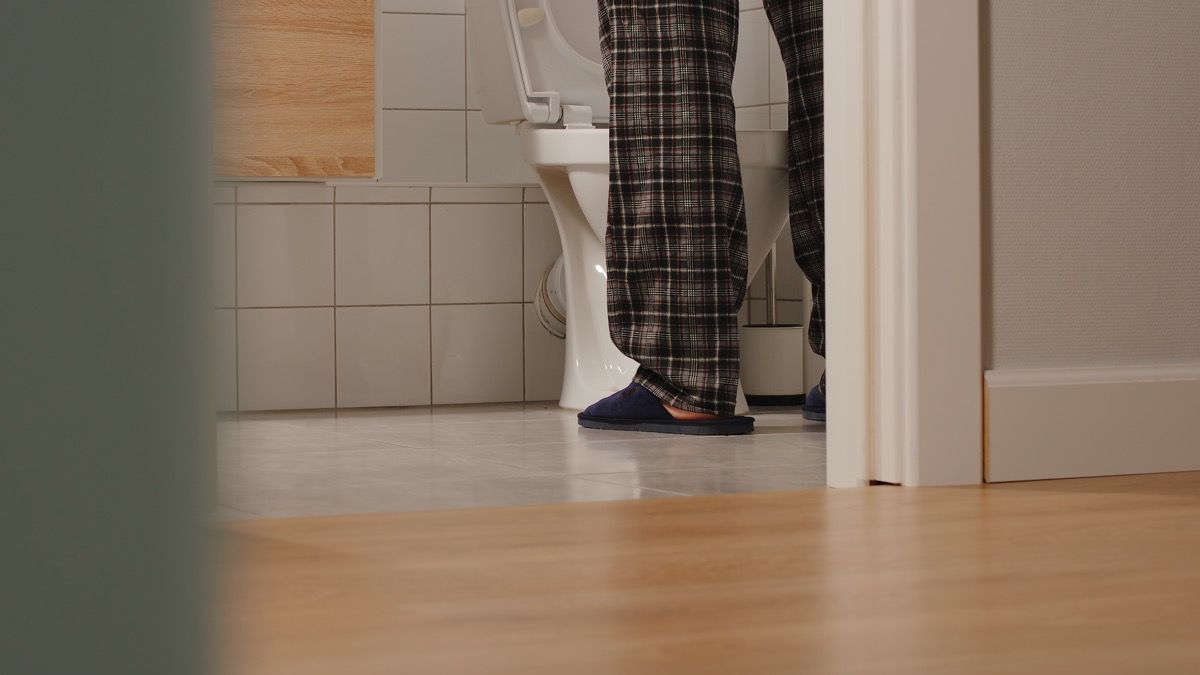 Άτομο που στέκεται δίπλα στην τουαλέτα