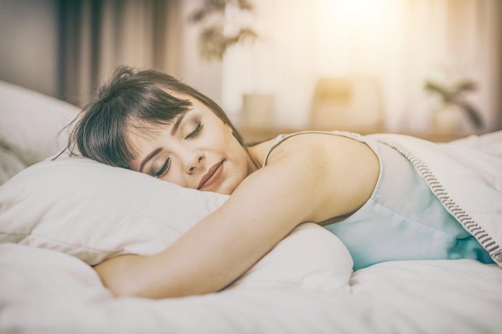 femeie care doarme pe pat