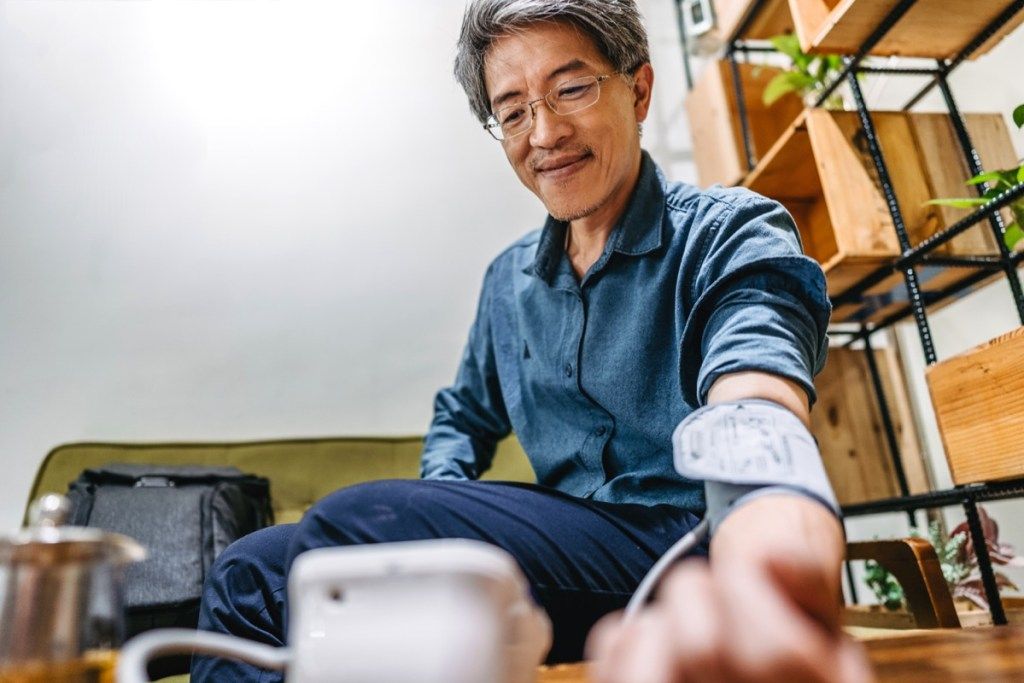 Ázsiai férfi ellenőrzi a vérnyomását