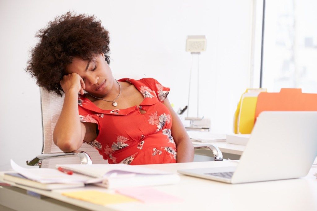 nainen, joka nukkuu työpöydällä, merkitsee aineenvaihduntaa hitaasti