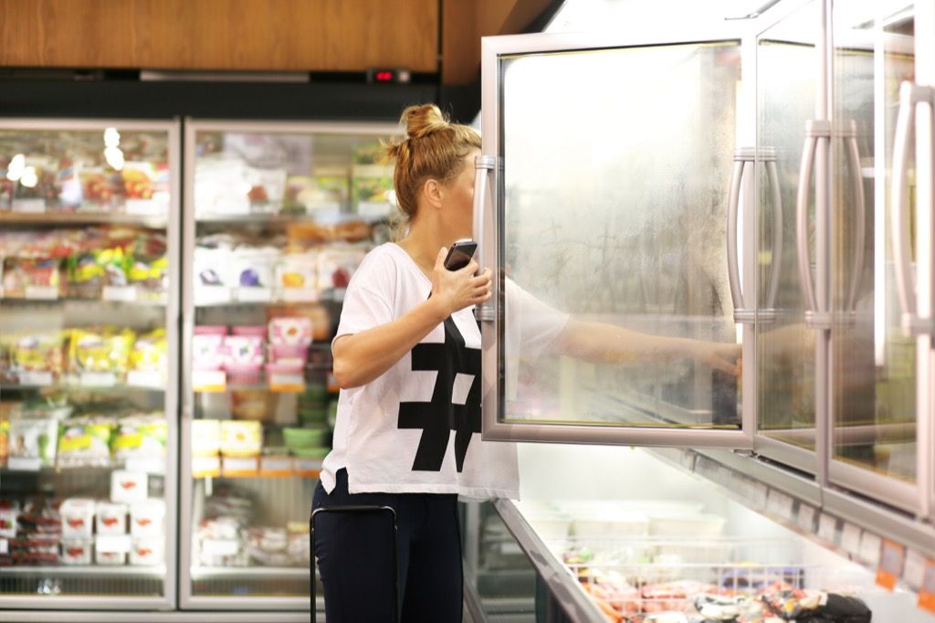 냉동 식품 통로에있는 여성 의사가 여행 중 피하는 음식