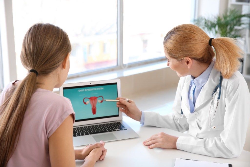Doctor profesor femeie despre corpul ei arătând spre uter