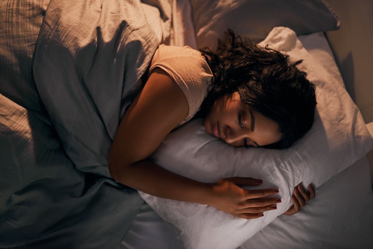 mlada ženska, ki spi v vzglavniku v postelji