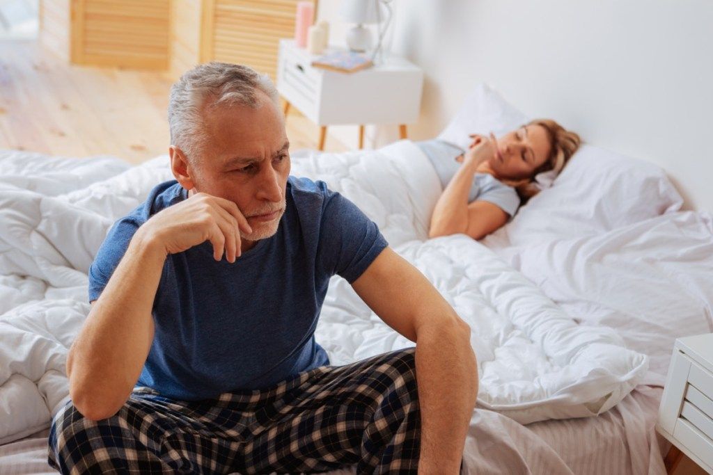 คู่โกรธนอนอยู่บนเตียงคำถามเกี่ยวกับสุขภาพอายุมากกว่า 40 ปี