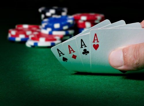 pokera kārtis, kas salocītas pokera žetonu priekšā