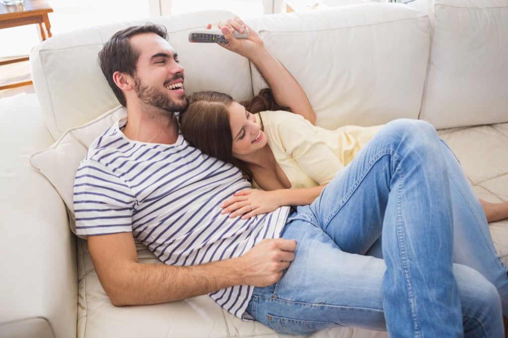 Couple en riant ensemble sur le canapé bienfaits du rire pour la santé