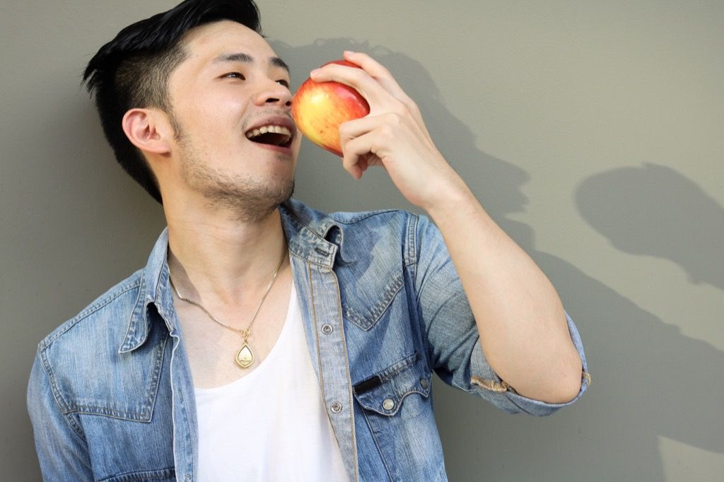 mees seljas teksapintsak ja sööb õuna