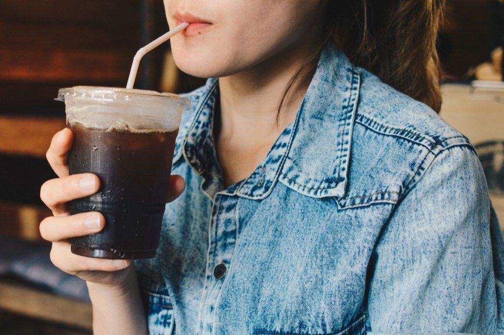 close-up van vrouw zwarte ijskoffie drinken