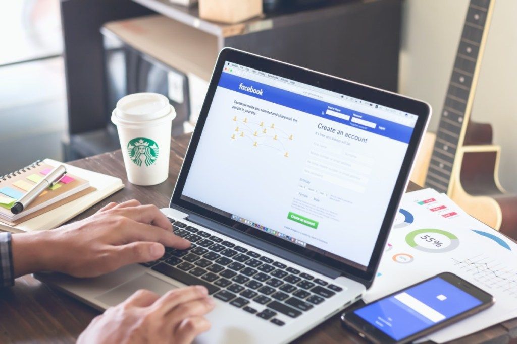 Asmuo, prisijungęs prie „Facebook“ nešiojamuoju kompiuteriu kavinėje