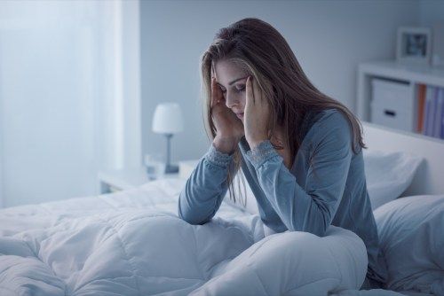 Depressziós nő ébren van az éjszakában, kimerült és álmatlanságban szenved