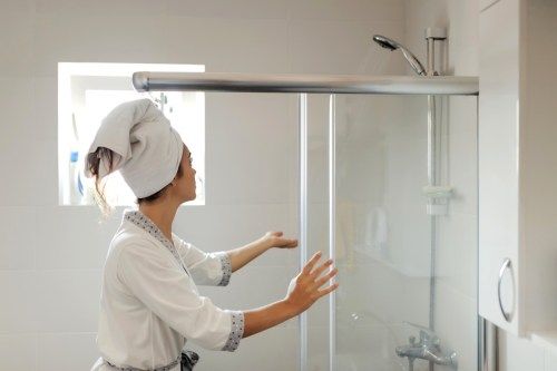 Giovane donna in accappatoio si prepara a fare la doccia in bagno a casa