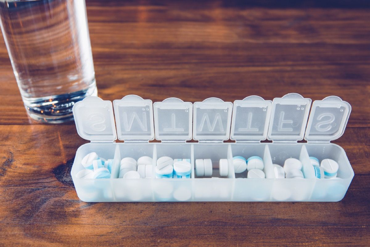 tablečių dėžutė ant stalo su stikline vandens