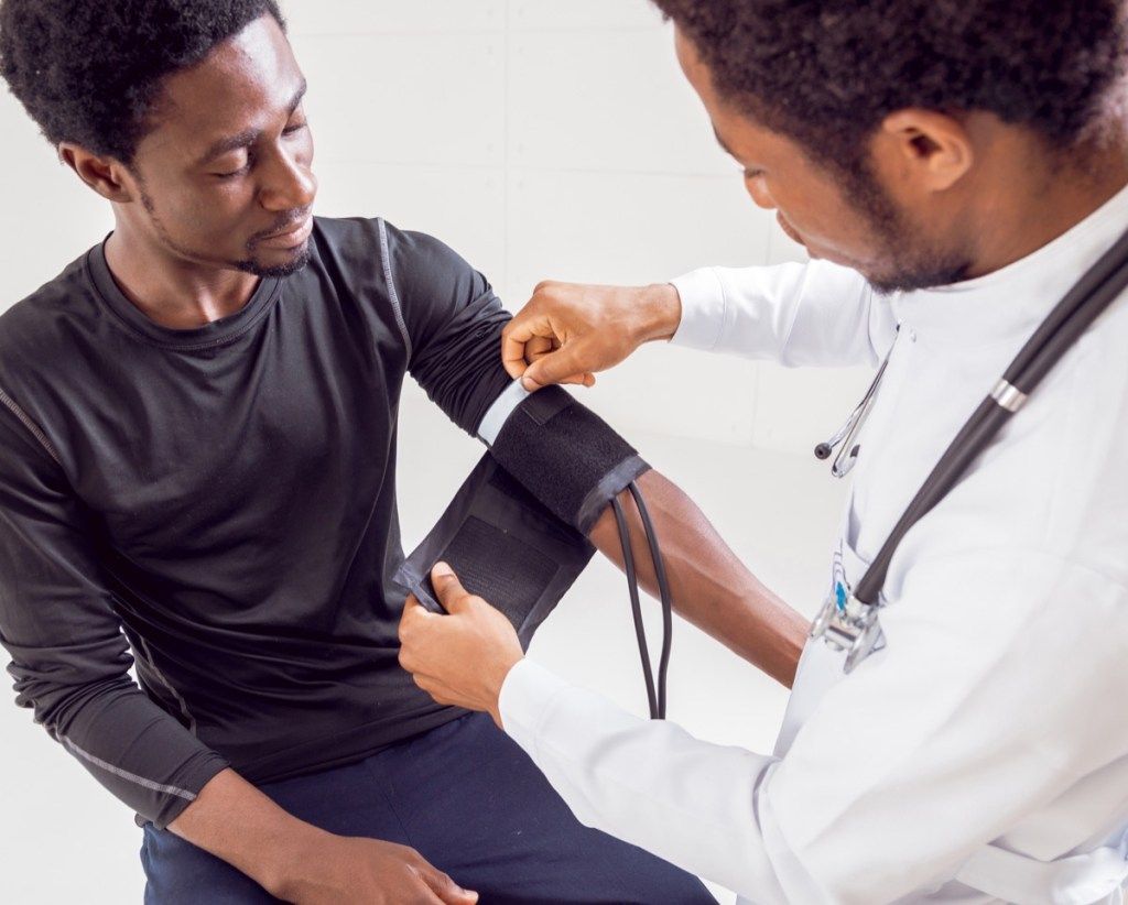 Homem verificando a pressão arterial no médico