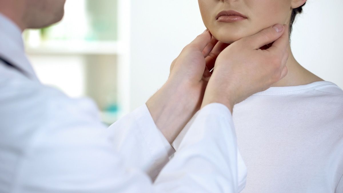 Femeia care își controlează tiroida este verificată de un medic