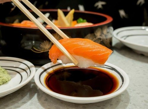 sushi, mida hoiavad söögipulgad, mis kastetakse sojakastmesse ebatervislik toit