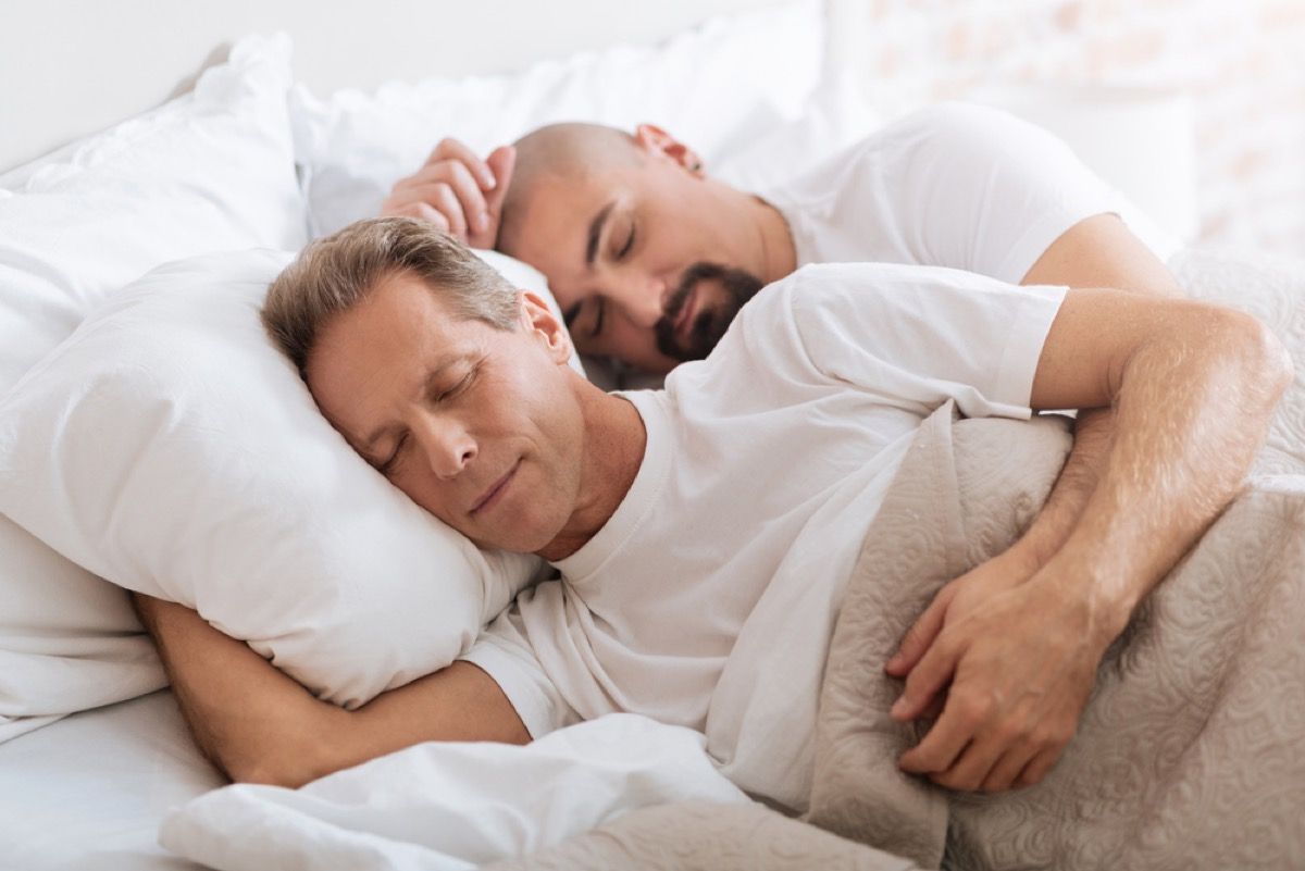 middelaldrende homofile par skjeer i sengen