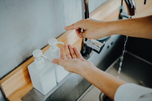 Ảnh cắt của một người đàn ông đang pha chế xà phòng trước khi rửa tay trong bồn rửa tay