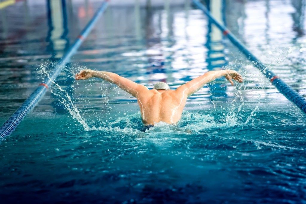 seorang pria yang berenang di kolam renang lintasan