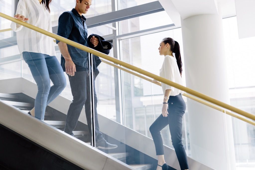 офисные работники поднимаются по лестнице