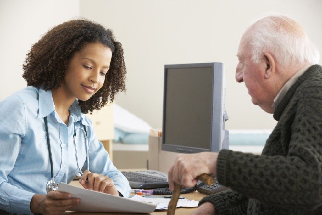 mlada crna ženska liječnica u razgovoru sa starijim bijelim pacijentom, čimbenici srčanog rizika