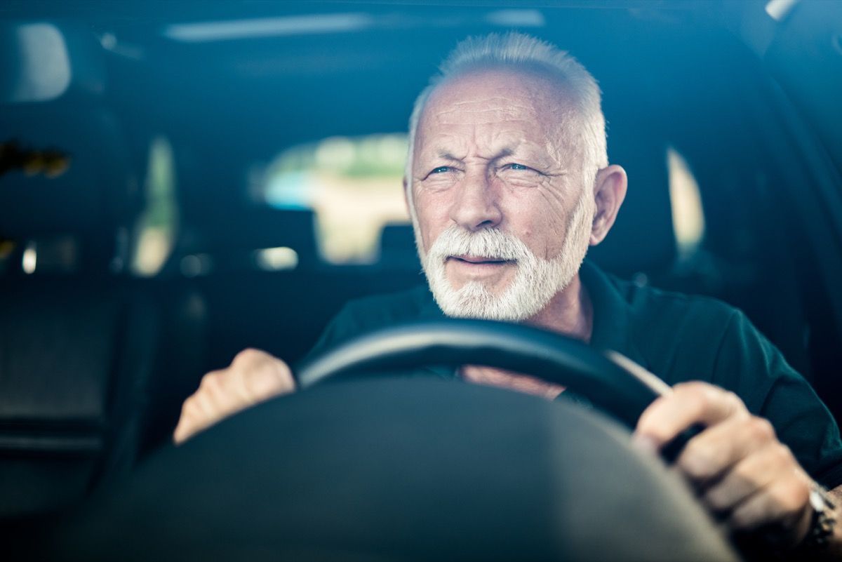 Hombre mayor que tiene mala vista y se esfuerza por ver la carretera.